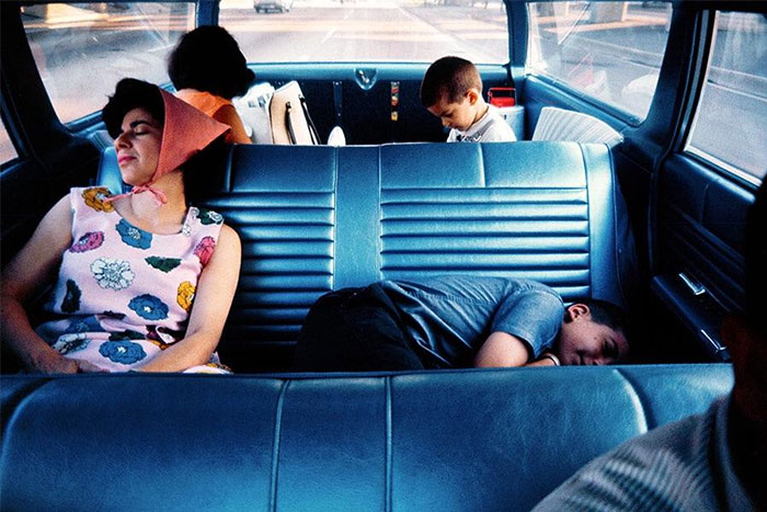 A family inside a vintage car, showcasing everyday American life from the past. A family inside a vintage car, showcasing everyday American life from the past.