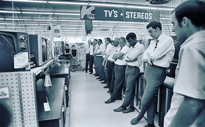 Men in a vintage electronics store, browsing TVs and stereos, depicting past everyday American life. Men in a vintage electronics store, browsing TVs and stereos, depicting past everyday American life.