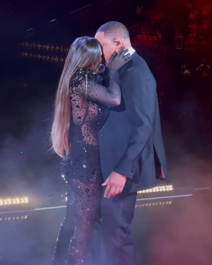 Two performers embrace on stage in dramatic lighting during a show. Two performers embrace on stage in dramatic lighting during a show.