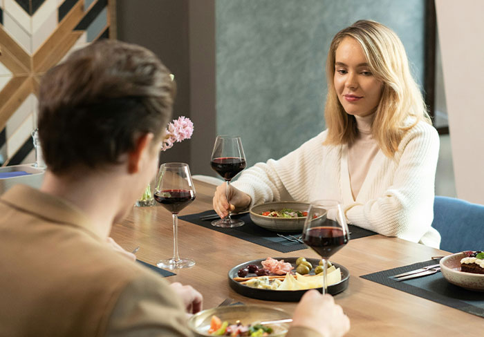 A woman and man dining together with wine, discussing relationships. A woman and man dining together with wine, discussing relationships.