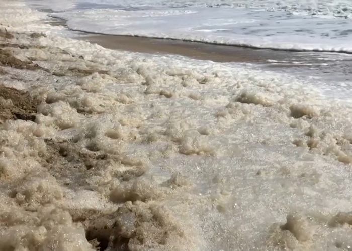 Sea foam filled with sewage on a sandy beach. Sea foam filled with sewage on a sandy beach.