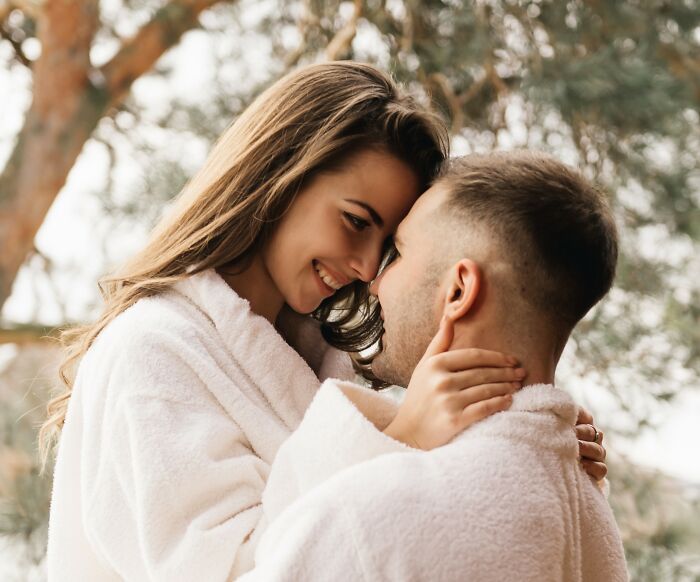 A couple in white robes share an intimate moment under trees, highlighting insignificant things stuck in precious memories.