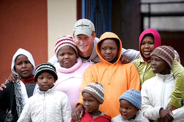 A group of people, including a man in a cap, posing together outside. A group of people, including a man in a cap, posing together outside.