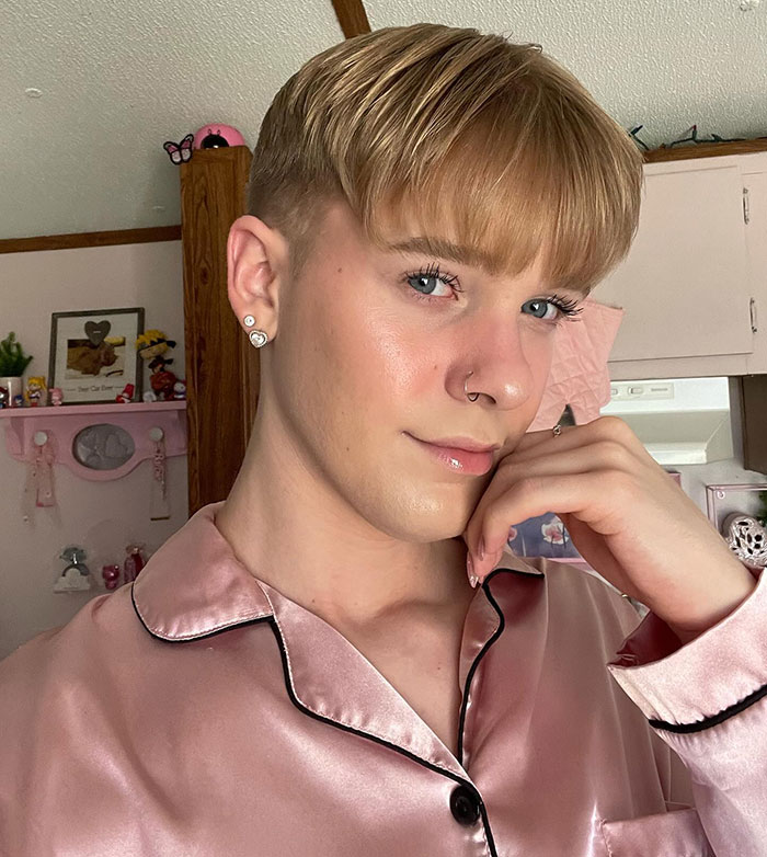 Person in pink satin shirt at home, related to daycare content controversy. Person in pink satin shirt at home, related to daycare content controversy.