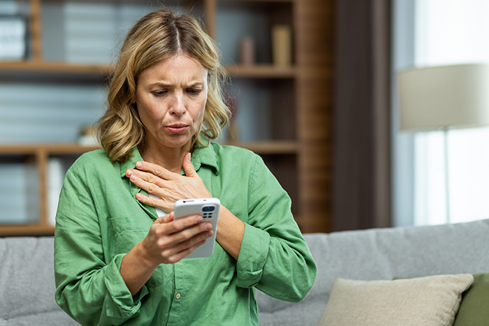 Woman in green shirt looking surprised at her phone, relates to teen calling friend's mom "weirdo. Woman in green shirt looking surprised at her phone, relates to teen calling friend's mom "weirdo.
