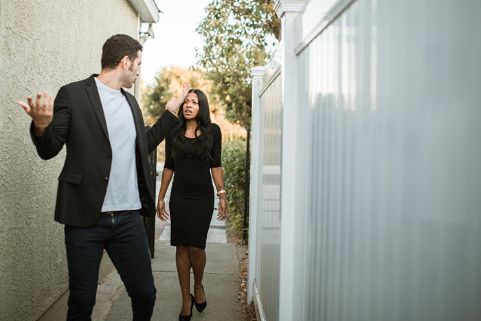 Man and woman arguing outdoors; possibly about a wedding's plus one policy. Man and woman arguing outdoors; possibly about a wedding's plus one policy.