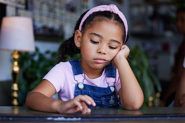 Young girl looking sad, wearing a pink headband and denim overalls, related to a babysitting incident about "unruly" hair. Young girl looking sad, wearing a pink headband and denim overalls, related to a babysitting incident about "unruly" hair.