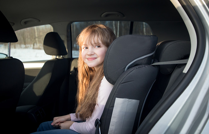 A smiling girl sits in a car seat, suggesting playdate excitement. A smiling girl sits in a car seat, suggesting playdate excitement.