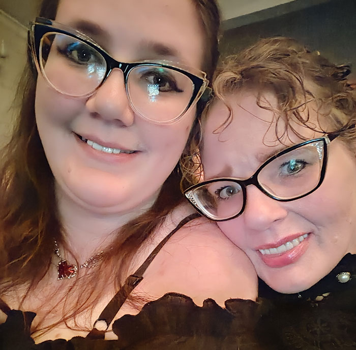 Two women wearing glasses smiling, related to tall cisgender women's workplace issue. Two women wearing glasses smiling, related to tall cisgender women's workplace issue.