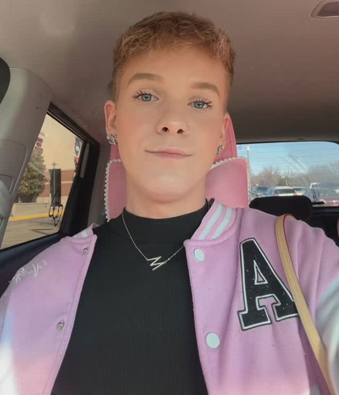 Individual in a car wearing a pink jacket with an "A" emblem, related to daycare adult content controversy. Individual in a car wearing a pink jacket with an "A" emblem, related to daycare adult content controversy.
