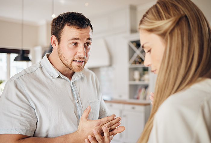 Man in a light shirt speaking to a woman in a kitchen, discussing a $25,000 demand after a 7-year relationship. Man in a light shirt speaking to a woman in a kitchen, discussing a $25,000 demand after a 7-year relationship.