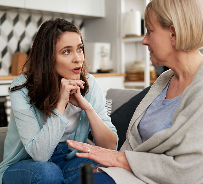 Two women engaged in a discussion about modern grandparenting double standards in a cozy living room. Two women engaged in a discussion about modern grandparenting double standards in a cozy living room.