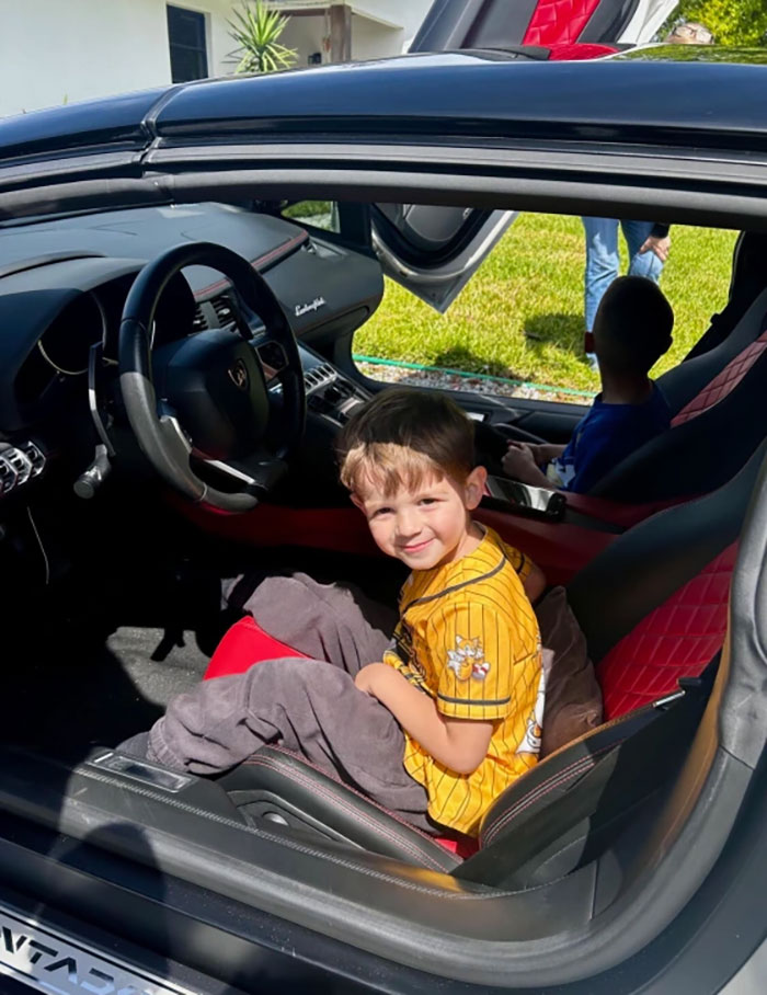 Child smiling in a Lamborghini sports car with open scissor doors, enjoying a birthday surprise from local car enthusiasts. Child smiling in a Lamborghini sports car with open scissor doors, enjoying a birthday surprise from local car enthusiasts.