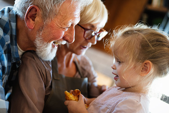 Grandparents smiling and interacting with granddaughter, highlighting modern grandparenting dynamics. Grandparents smiling and interacting with granddaughter, highlighting modern grandparenting dynamics.