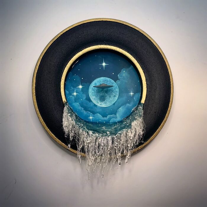 Alien-themed diorama by Caroline Dewison featuring a UFO, moon, and cascading water effect in a circular frame.