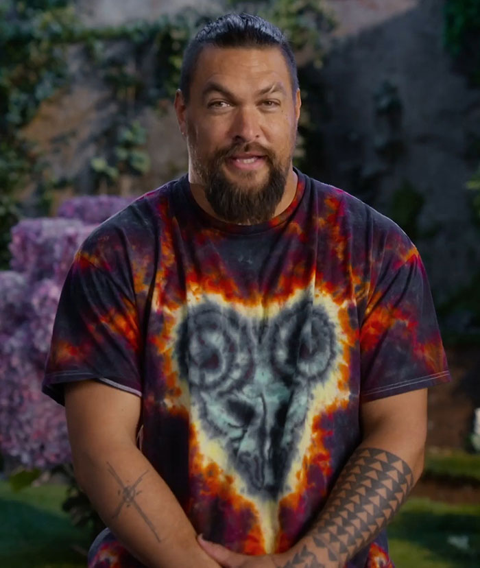Man in a colorful shirt with tattoos, standing outdoors. Man in a colorful shirt with tattoos, standing outdoors.