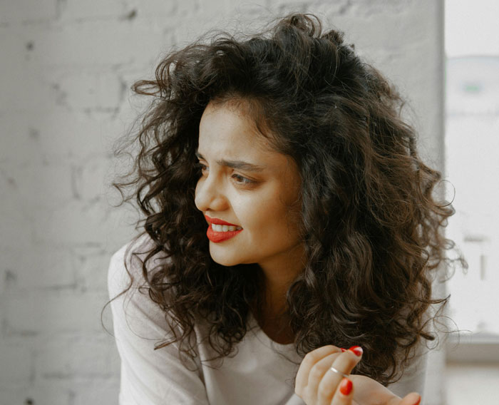 Woman with curly hair and red lipstick, following break policy, watching kitchen chaos unfold. Woman with curly hair and red lipstick, following break policy, watching kitchen chaos unfold.