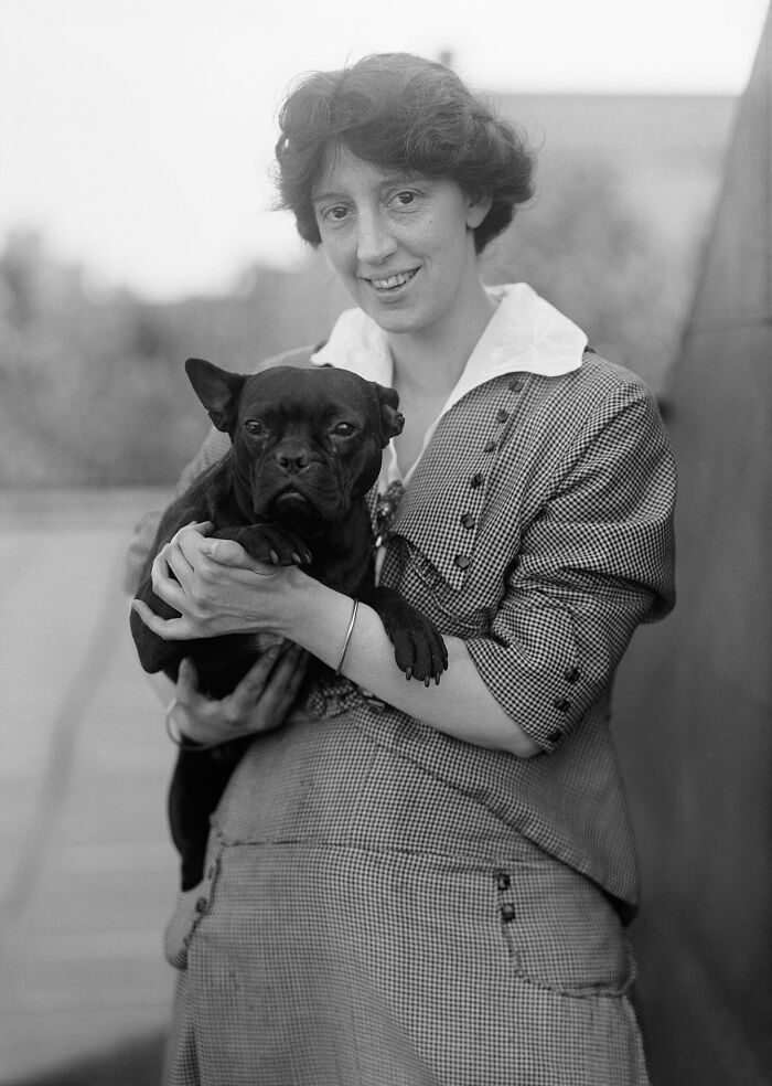 Black and white rare photograph of a woman holding a small dog, rescued from glass negatives and history restored.