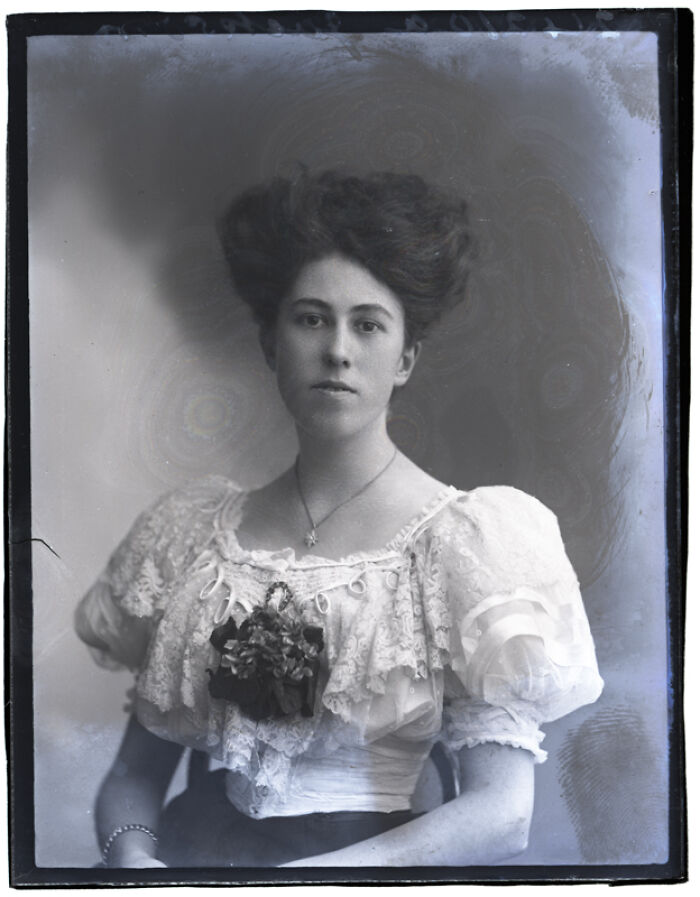 Black and white rare photograph of a young woman in vintage dress rescued from glass negatives showcasing history restored.