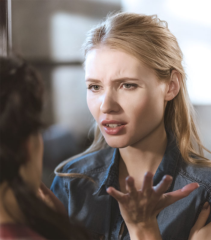 Woman looking frustrated, gesturing during a miscommunication about babysitting with in-laws. Woman looking frustrated, gesturing during a miscommunication about babysitting with in-laws.