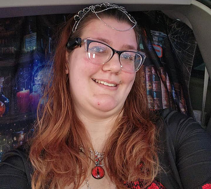 Smiling tall woman with glasses and jewelry, seated, colorful backdrop. Smiling tall woman with glasses and jewelry, seated, colorful backdrop.