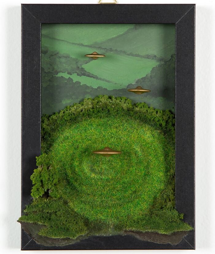 Framed diorama of green landscape with UFOs, perfect for alien enthusiasts by Caroline Dewison.