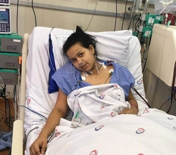 Woman in hospital bed after transplants, wearing a hospital gown, connected to medical equipment. Woman in hospital bed after transplants, wearing a hospital gown, connected to medical equipment.