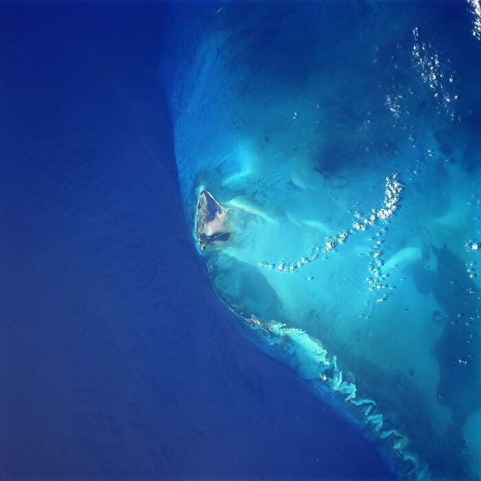 Aerial view of an ancient artifact submerged in deep blue ocean waters.