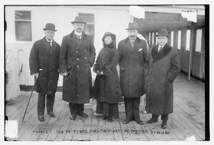 Five individuals wearing early 20th-century attire standing on a ship deck in rare photographs rescued from glass negatives.