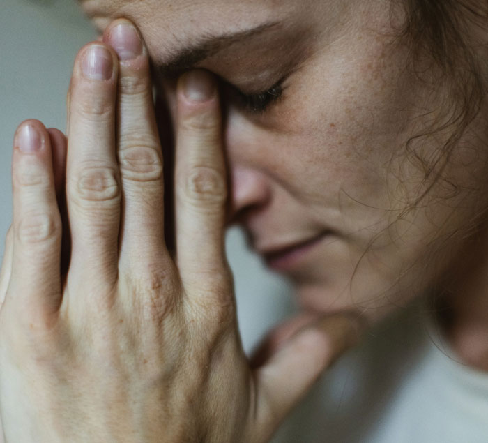 Close-up of a distressed woman with her hands on her face, emphasizing emotion and tension. Close-up of a distressed woman with her hands on her face, emphasizing emotion and tension.