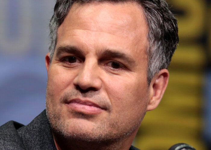 Man at a speaking event, wearing a dark blazer, highlighting celebrity kindness.