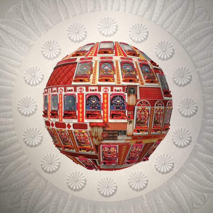 Surreal floating sphere painted to represent a post-apocalyptic urban city with intricate red architectural details.