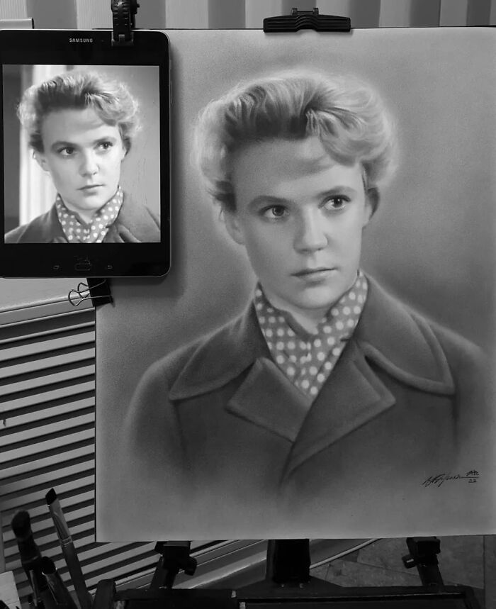 Hyper-realistic pencil portrait beside a photo reference on a tablet.