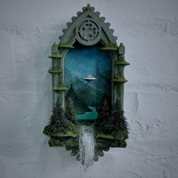 Mystery diorama by Caroline Dewison featuring an alien spacecraft over a serene landscape with mountains and trees.
