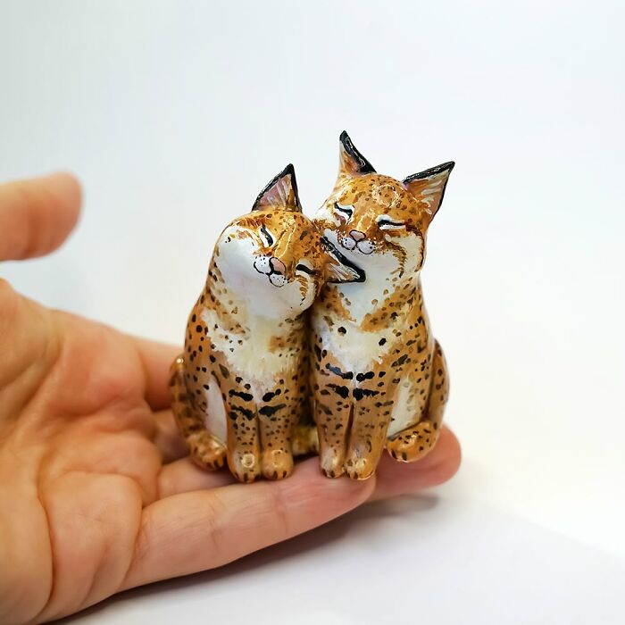 Hand holding two pocket-sized adorable animal figurines by Vallavica.