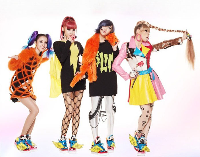 K-Pop stars posing in colorful outfits, showcasing bold fashion choices amid plastic surgery rumors. K-Pop stars posing in colorful outfits, showcasing bold fashion choices amid plastic surgery rumors.
