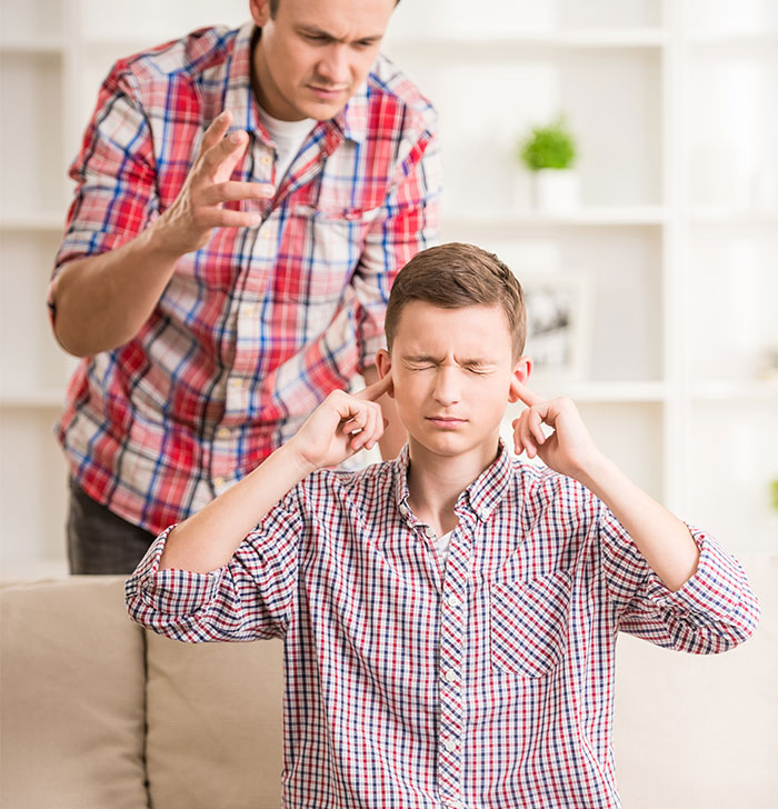 Teen blocks ears as man talks, expressing frustration from years of harassment labeled as a "harmless prank. Teen blocks ears as man talks, expressing frustration from years of harassment labeled as a "harmless prank.