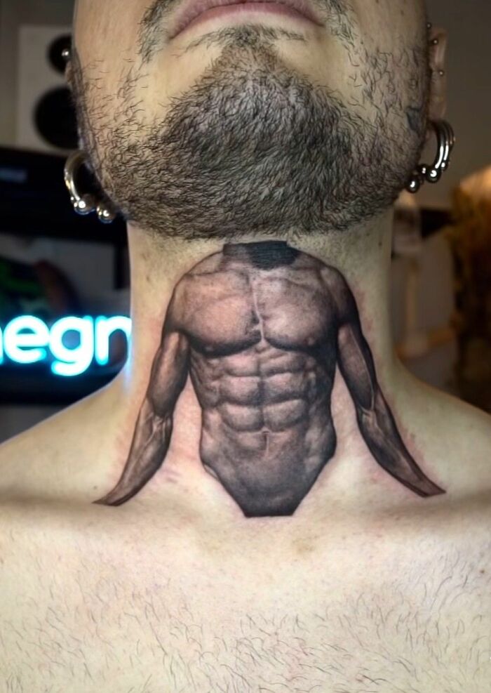 Close-up of a hilariously bad tattoo on a man's neck, depicting a muscular torso.