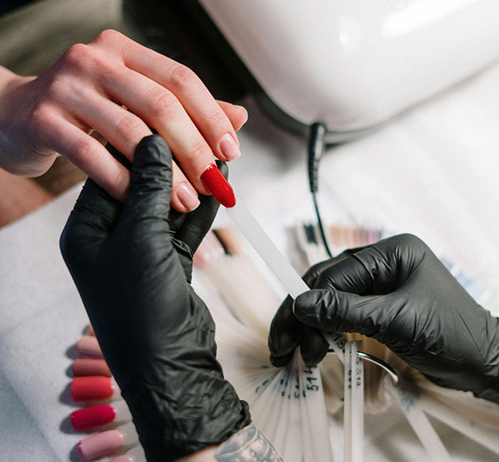 Gloved hands doing nail art with red polish, sparking patriarchy debate related to a short-nail theory. Gloved hands doing nail art with red polish, sparking patriarchy debate related to a short-nail theory.