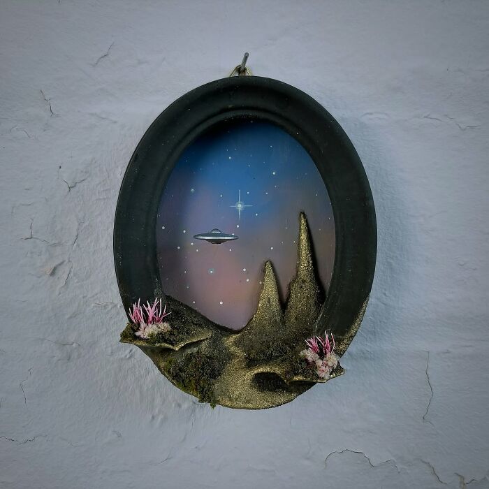 Alien diorama in an oval frame, depicting a UFO in a starry night sky with mysterious landscapes.