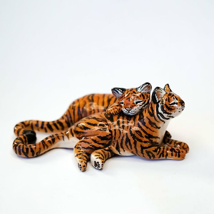 Pocket-sized tiger figurines by Vallavica, featuring a mother and cub in a relaxed pose.