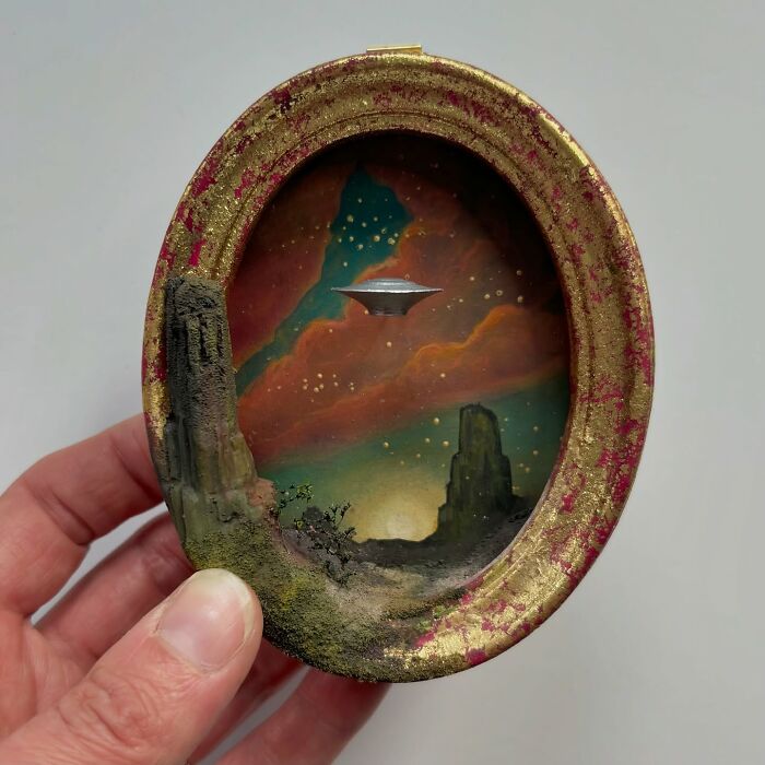 Miniature diorama depicting UFO in an alien landscape, held in a hand, ideal for mystery enthusiasts.