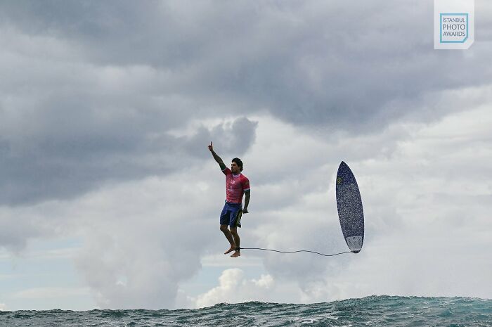 Surfer appears to walk on water in dramatic ocean scene, Istanbul Photo Awards 2025.