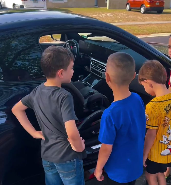Children admire a sleek sports car surprise for a birthday celebration. Children admire a sleek sports car surprise for a birthday celebration.