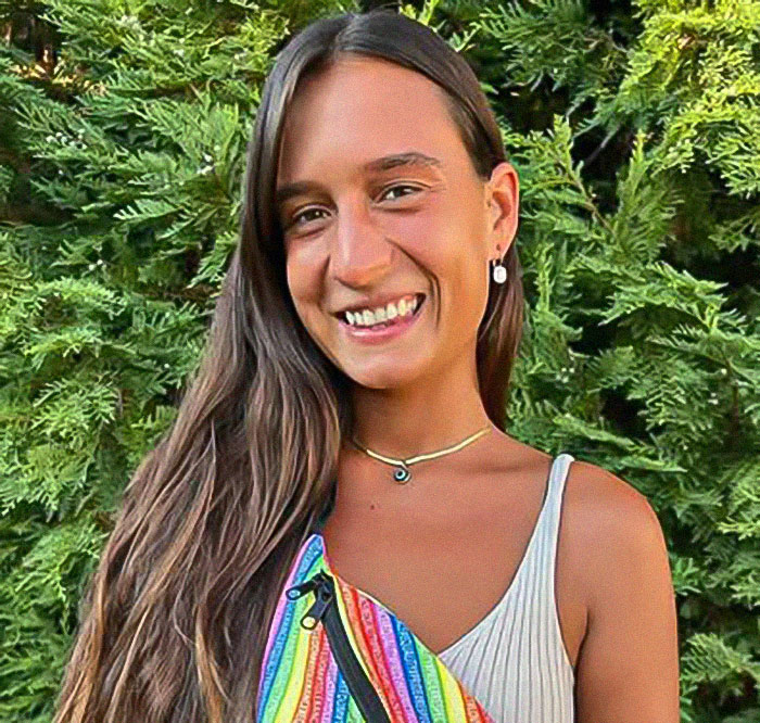 Young woman smiling outdoors, wearing a colorful dress. Young woman smiling outdoors, wearing a colorful dress.