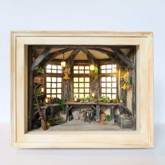 Miniature rustic room by Tamar Cohen, featuring detailed furniture and decorations in a wooden frame.