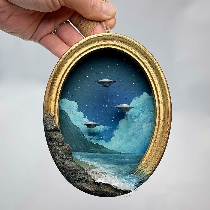 Miniature diorama with UFOs over an ocean scene in an oval frame, perfect for mystery aficionados.