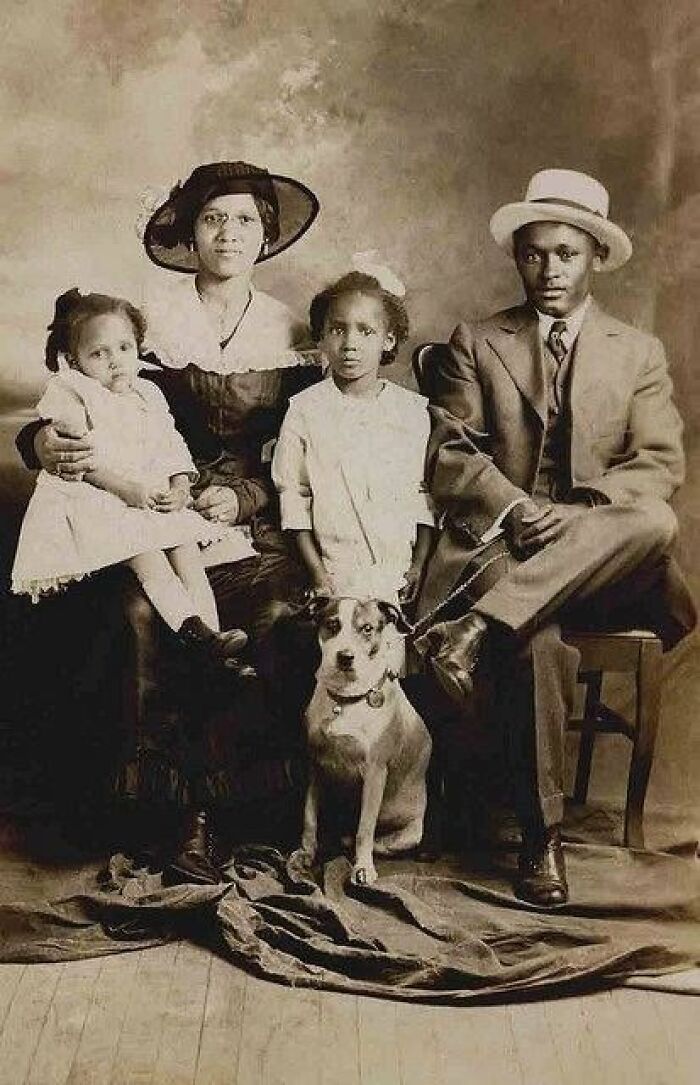 African American family portrait over a century ago, showcasing strength, unity, and resilience with children and a dog.