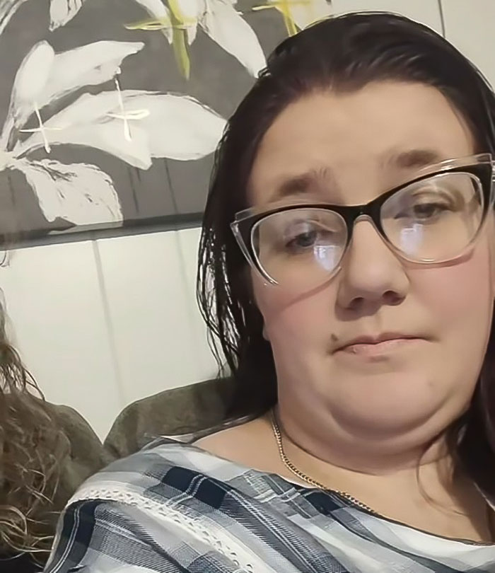 A woman in glasses looks at the camera, reflecting issues faced by tall cisgender women at work. A woman in glasses looks at the camera, reflecting issues faced by tall cisgender women at work.