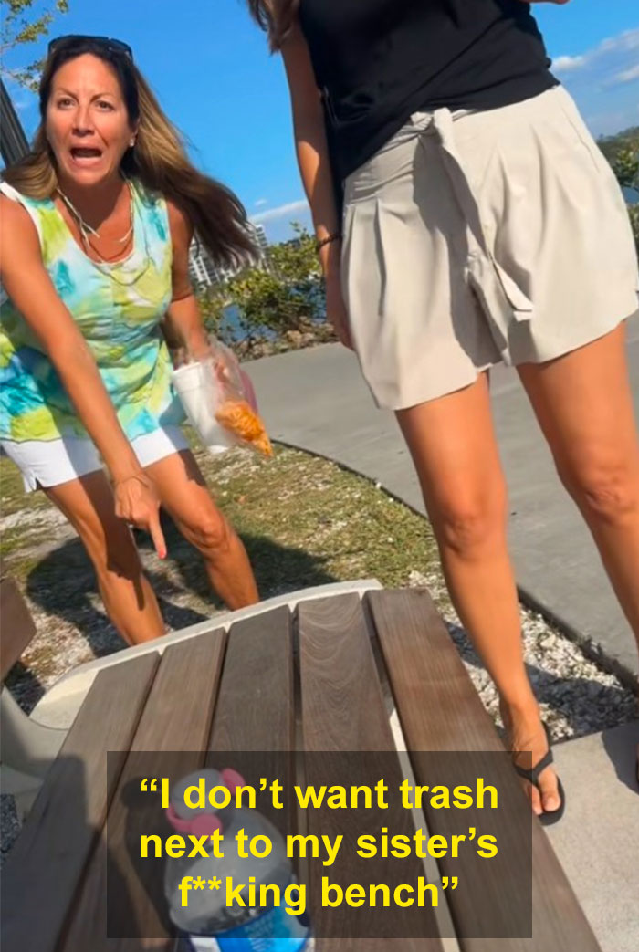 Woman angrily gesturing at a park bench while another stands nearby, both appearing upset during a public confrontation. Woman angrily gesturing at a park bench while another stands nearby, both appearing upset during a public confrontation.